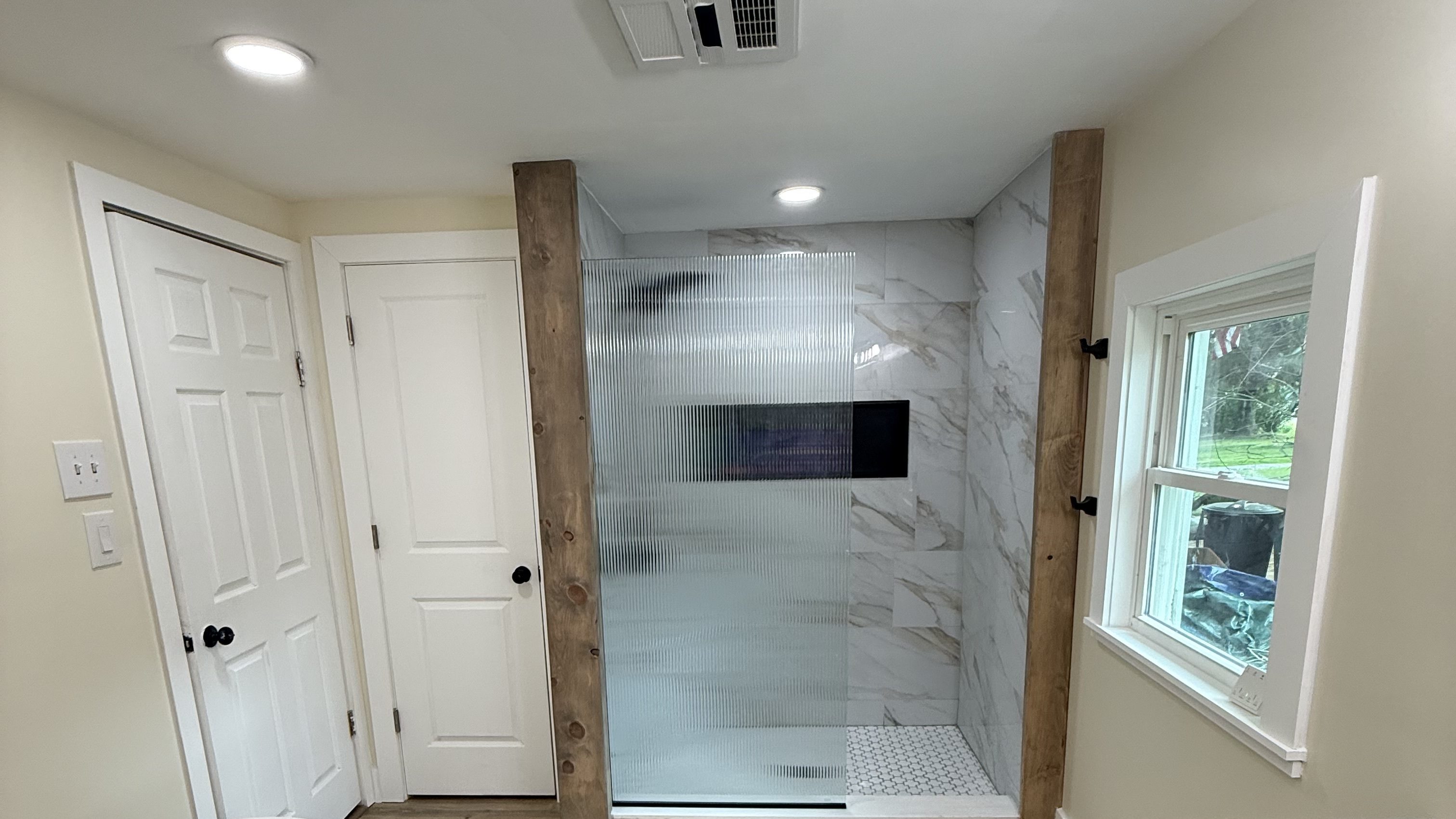 Remodeled bathroom with a freestanding tub, walk-in shower and wood-look tile floor