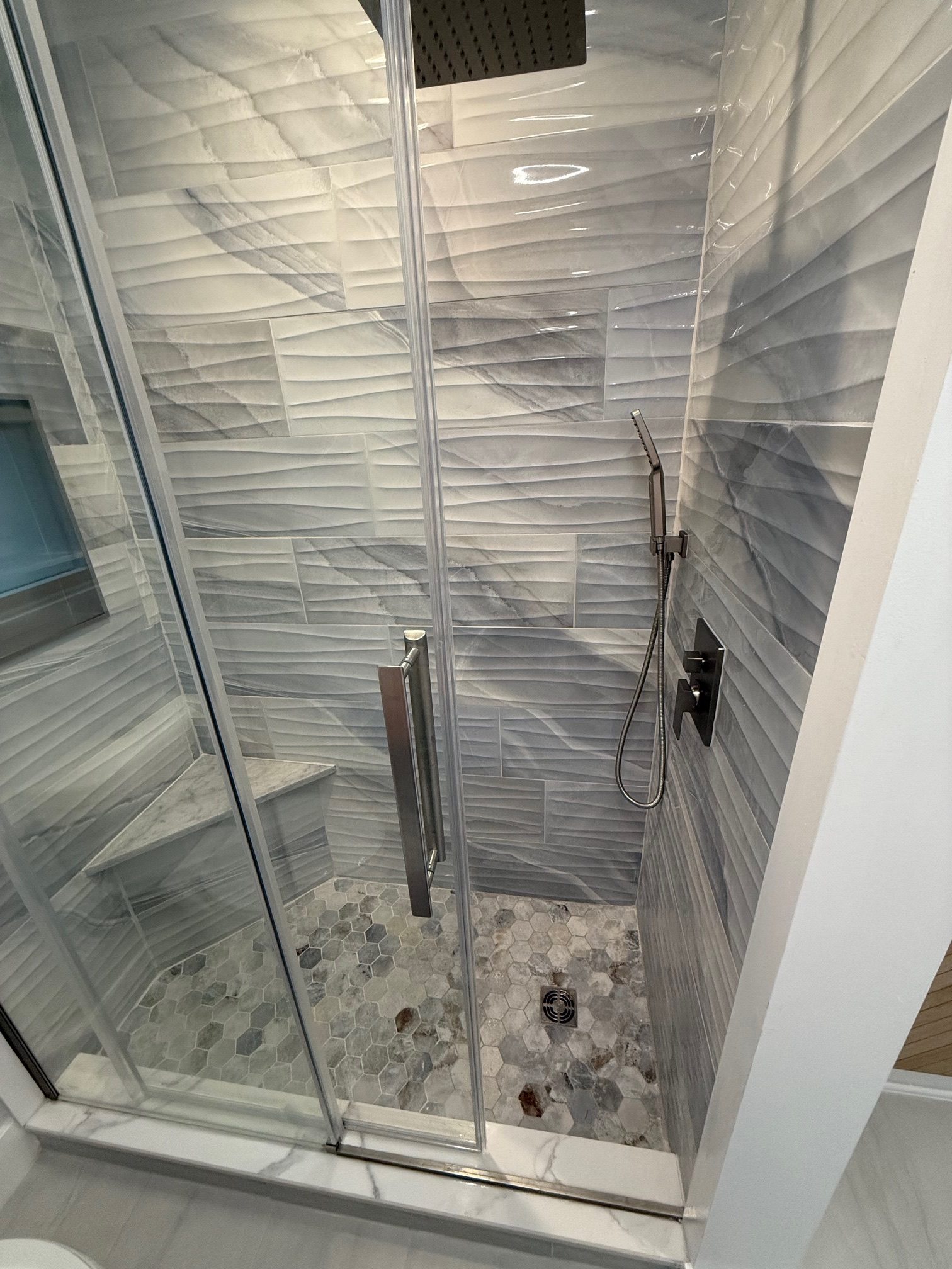 Custom tile shower with a glass door built by TGF Remodeling