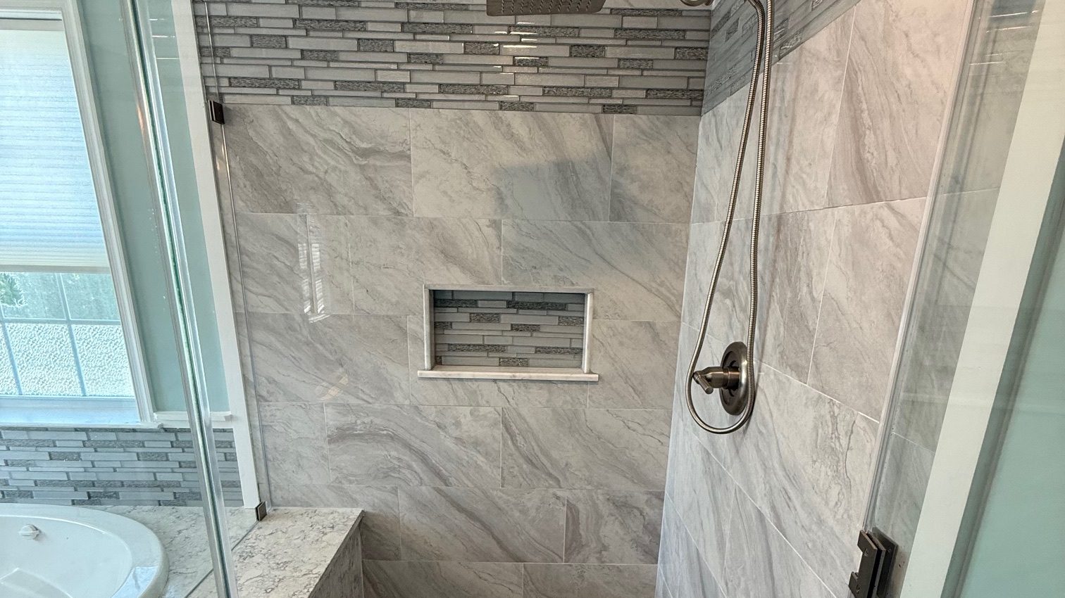 Custom tile walk-in shower with glass enclosure by TGF Remodeling