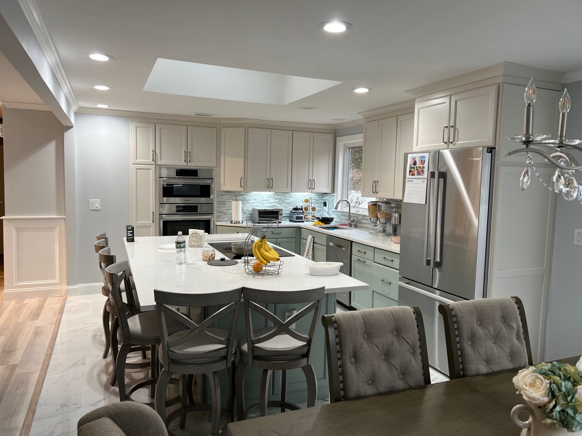 Remodeled kitchen with an island and wall ovens by TGF Remodeling